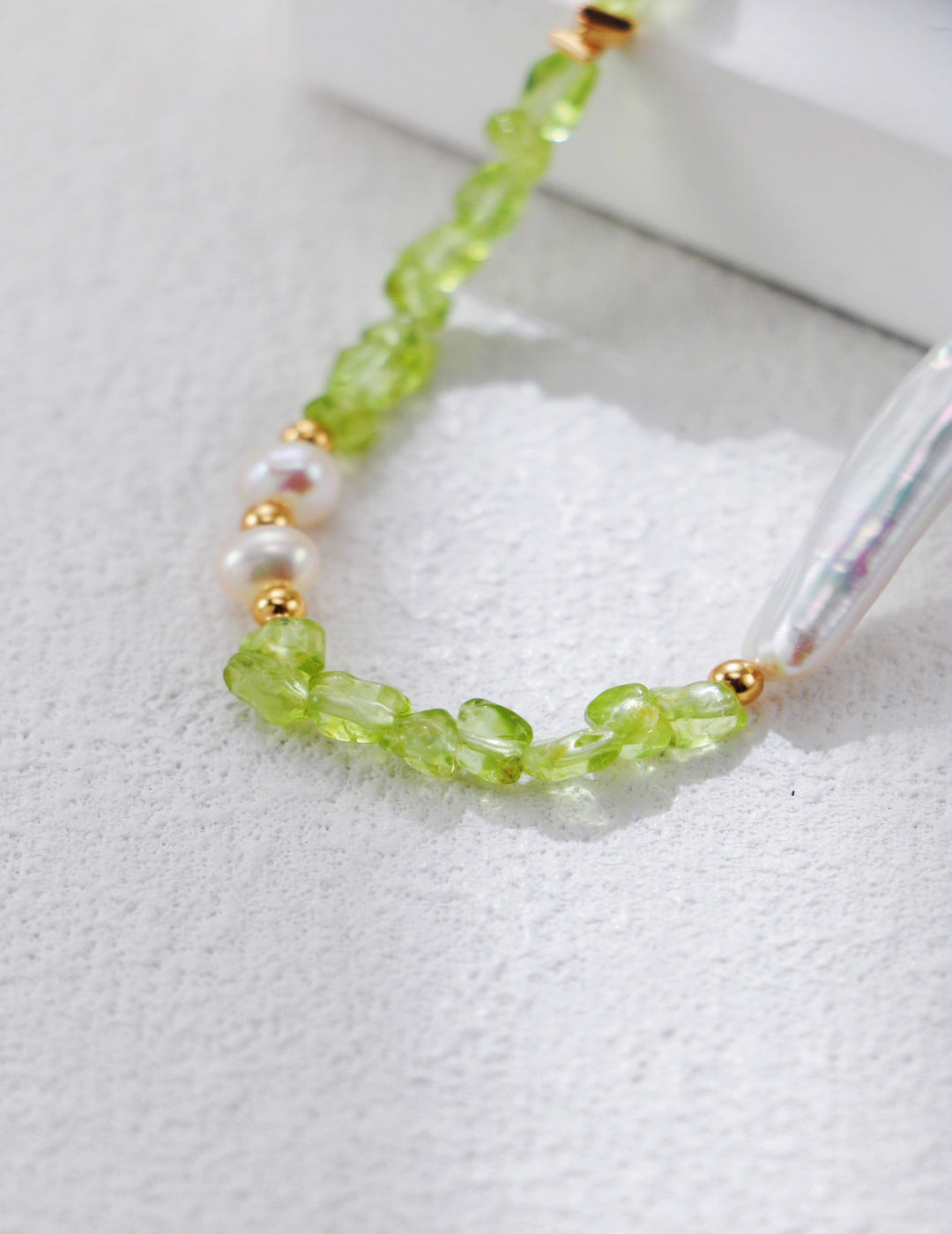 This handcrafted S925 silver necklace features natural pearls and olive-green peridot gemstones, accented with retro gold detailing. Its vintage-inspired design and elegant color palette make it a timeless accessory for both everyday wear and special occasions.