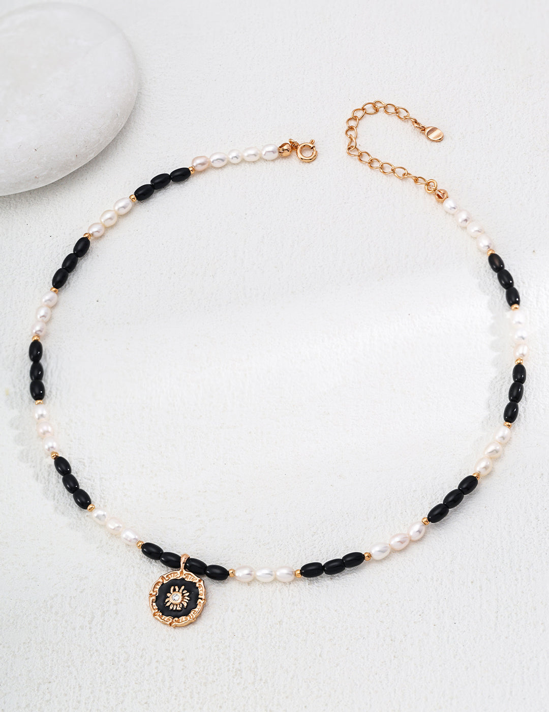 This S925 silver pendant features a refined combination of natural pearl and black onyx, enhanced by a glossy enamel finish. The artistic black-and-white contrast adds a sophisticated touch, making it perfect for both everyday wear and special occasions.