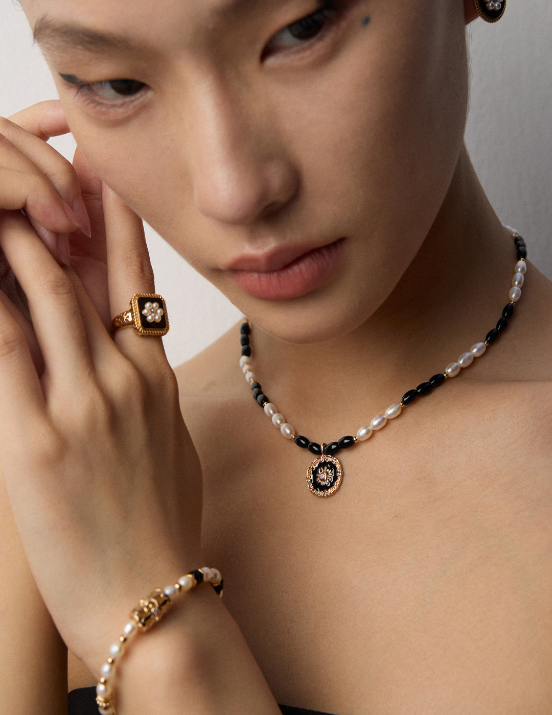 This S925 silver necklace features a sleek enamel pendant accented with a luminous pearl and deep black onyx. Its minimalist black-and-white palette adds refined contrast, making it ideal for modern, everyday styling or as a timeless statement piece.