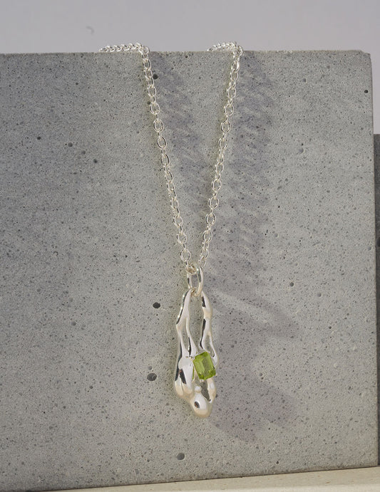 This necklace features a natural peridot gemstone in a minimalist setting, offering a fresh pop of green with refined elegance. Set on a delicate chain, it’s perfect for everyday wear, layering, or as a thoughtful August birthstone gift.