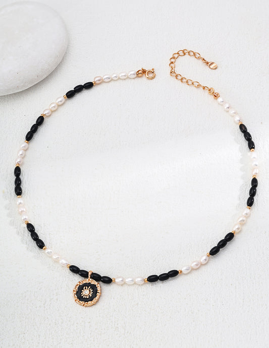 This S925 silver pendant features a refined combination of natural pearl and black onyx, enhanced by a glossy enamel finish. The artistic black-and-white contrast adds a sophisticated touch, making it perfect for both everyday wear and special occasions.