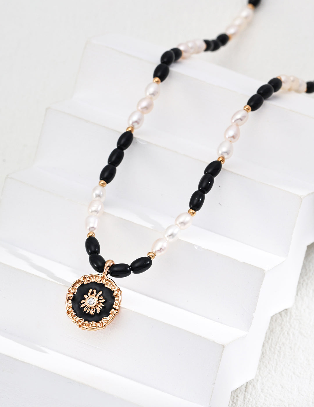 This S925 silver necklace features a pendant combining natural pearl, black onyx, and glossy enamel in a refined design. Its bold black-and-white contrast and smooth finish make it a sophisticated accessory for both everyday elegance and formal occasions.