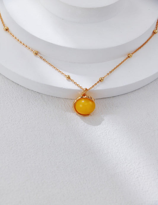 Close-up of a vintage-style S925 silver necklace with a gold-toned honey amber pendant, showcasing its warm glow and retro charm