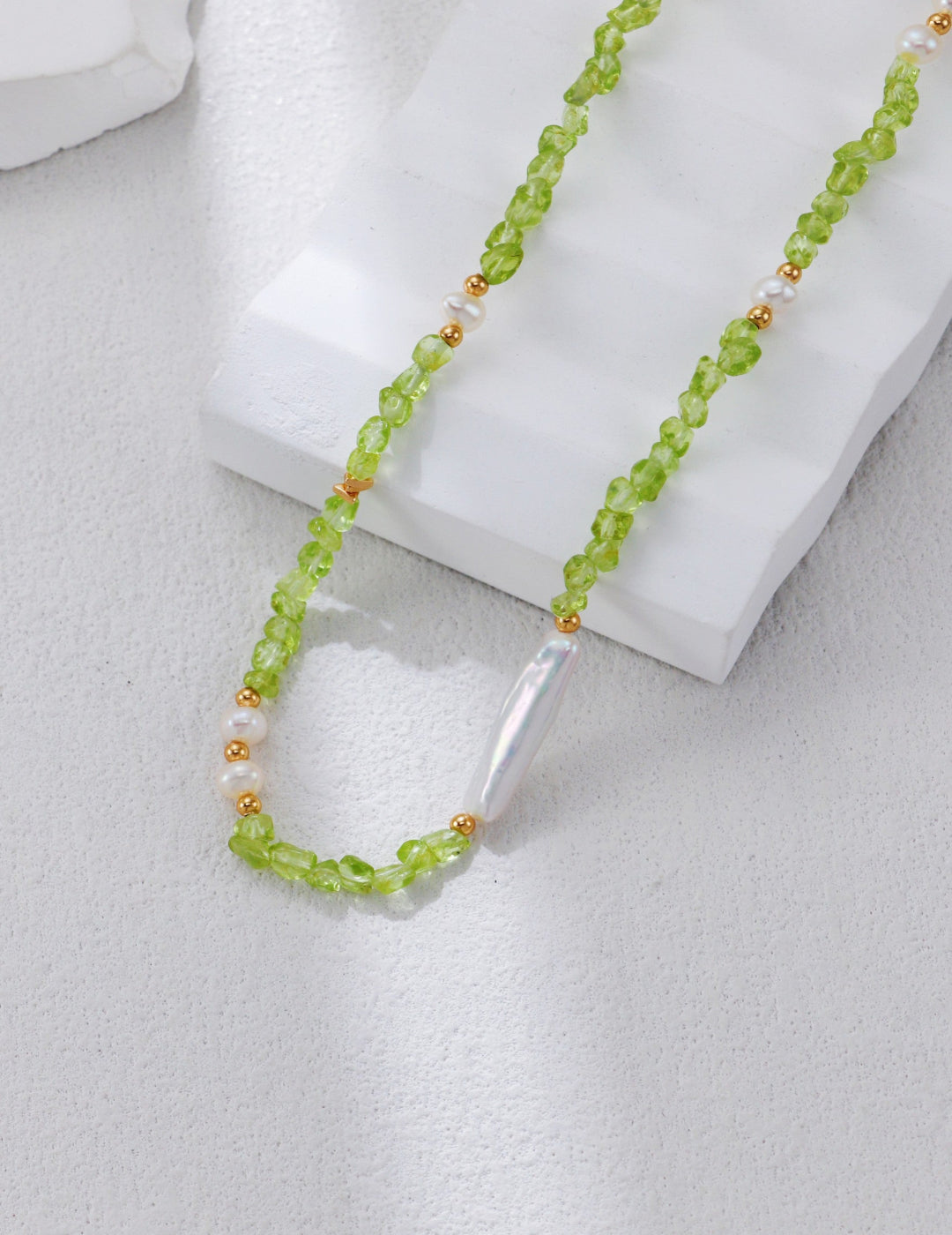 This vintage-inspired necklace features luminous pearls and vibrant green peridot set in S925 silver. The refined design blends classic charm with natural beauty, making it an ideal accessory for everyday wear or formal occasions.
