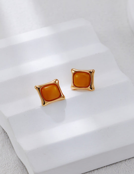 These vintage-inspired S925 silver stud earrings feature natural amber stones with gold accents. The warm amber, combined with the subtle gold detailing, creates a classic design that adds sophistication to any look, perfect for both everyday wear and special occasions.